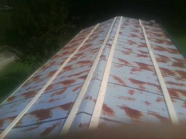 Rusted metal roof panels with new wood purlins before replacement — Storm Damage Roof Repair in Greensburg by Roofing Brothers